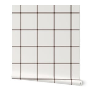 May include: A roll of white wallpaper with a brown plaid pattern. The grid design features evenly spaced vertical and horizontal lines, creating a classic, neutral aesthetic. The roll is partially unrolled, revealing the pattern.