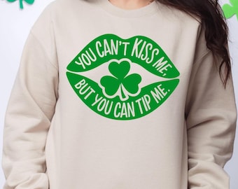 May include: A beige sweatshirt with a green shamrock and the text "You can't kiss me, but you can tip me." printed on the front.