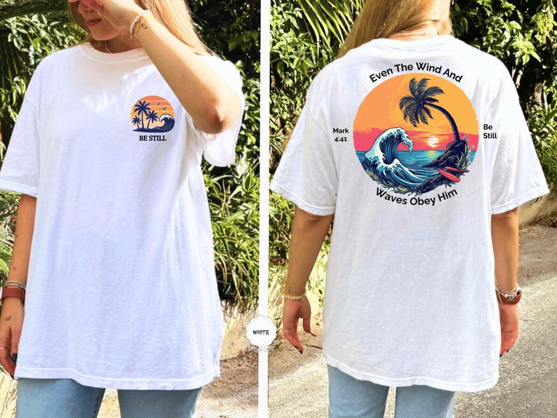 May include: White t-shirt with a beach-themed graphic. The front features a sunset, palm trees, and the words "BE STILL." The back displays a circular design with a palm tree, waves, and the text "Even The Wind And Waves Obey Him."