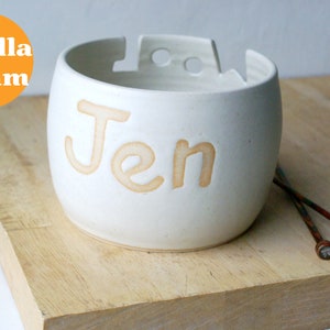 A ceramic wool yarn bowl glazed in vanilla with the name 'Jen'
