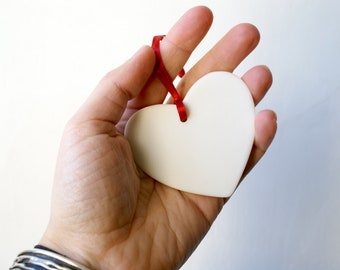 Hand cut porcelain heart decoration with smooth white finish ready for hanging