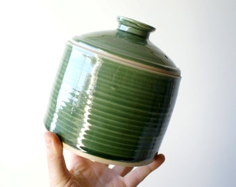 Hand thrown ceramic lidded jar glazed in forest green made from stoneware clay