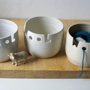 A set of three wool yarn bowls in white, vanilla and transparent glazes