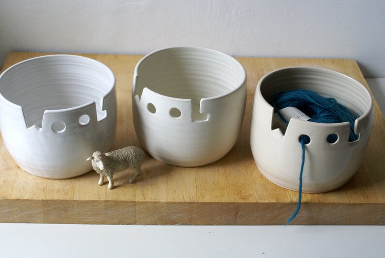 A set of three wool yarn bowls in white, vanilla and transparent glazes