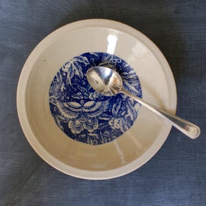 Handmade shallow ceramic bowl with blue butterfly design