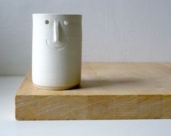 One small ceramic vase with face design - glazed in vanilla cream