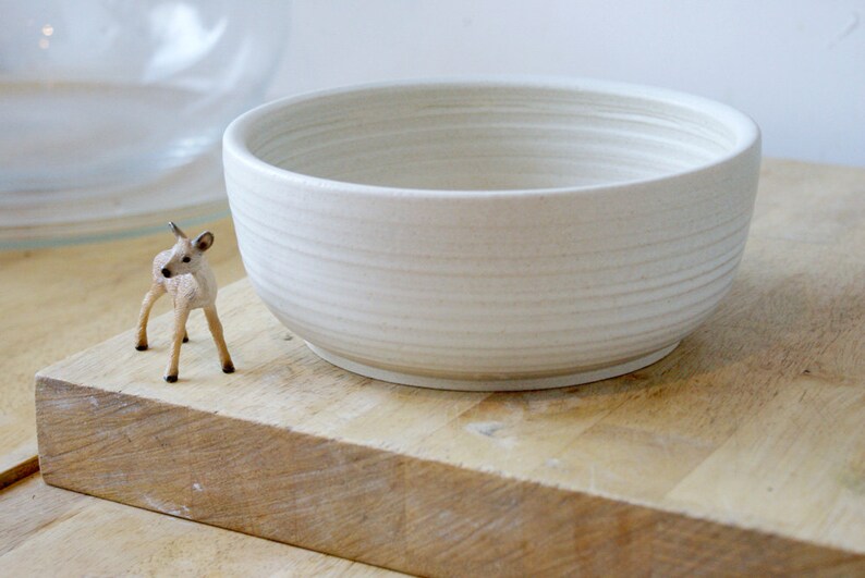 A stoneware pottery large salad bowl glazed in vanilla cream