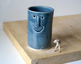 One ceramic vase with face design - glazed in ice blue