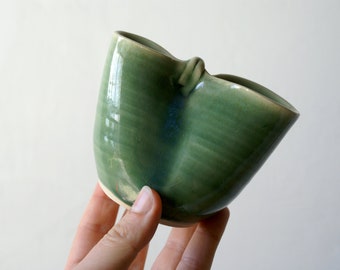 Hand thrown green glazed milk jug with unique squishy design