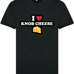 May include: Black t-shirt featuring the text "I ❤️ KNOB CHEESE" in white, a red heart, and a cheese wedge graphic. The shirt has a crew neck design.