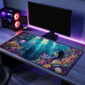 May include: A large, colourful mouse mat with an underwater scene featuring jellyfish, coral, and a sea turtle. The mouse mat is on a desk with a computer monitor and speakers.