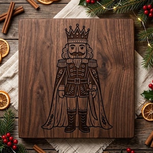 May include: A square dark brown wooden cutting board featuring a laser-engraved illustration of a nutcracker wearing a crown and a long cape. The nutcracker design includes detailed military-style uniform elements, a sword, and holly leaf accents.
