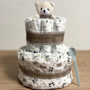 Torta di pannolini di alta qualità con fantastico materiale fasciatoio per ragazzi e ragazze. Include peluche e cucchiaio per il porridge. A scelta anche personalizzato.