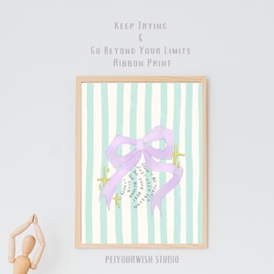 Op de afbeelding: Een ingelijste print met een illustratie van een lichtpaars lint. De achtergrond heeft verticale strepen in lichtblauw en wit. De tekst luidt "Keep Trying & Go Beyond Your Limits Ribbon Print". De print heeft ook de tekst "Don't be afraid, Keep trying, Just do your best, Go beyond your limits."