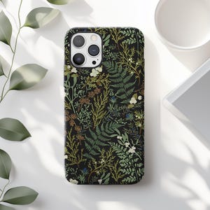 May include: A black phone case with a floral pattern featuring green leaves, white flowers, and brown accents.