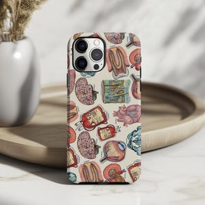 May include: A phone case featuring a repeating pattern of colorful anatomical illustrations, including the brain, heart, and eye. The case has a light beige background and a glossy finish, offering a unique and educational design.