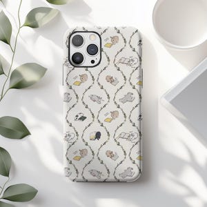 May include: A white phone case featuring a repeating pattern of cartoon animals reading books. The animals are in various poses, with some lying down and others sitting. The design includes a floral vine motif.
