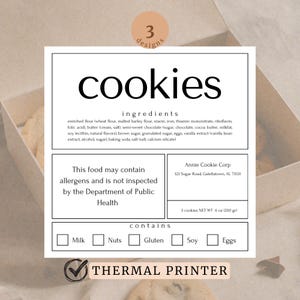 May include: A white label with black text that reads "cookies" and lists the ingredients, allergens, and contains information. The label also includes the company name and address, "Annie Cookie Corp, 123 Sugar Road, Galettatown, AL 73531". The label has a checkmark next to "THERMAL PRINTER" and a box with the text "Milk" is checked.