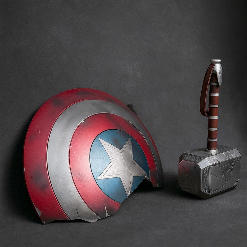 May include: A weathered Captain America shield with a missing section, featuring red, white, and blue concentric circles and a white star. Next to it is Thor's hammer, Mjolnir, with a brown leather strap and a silver head.