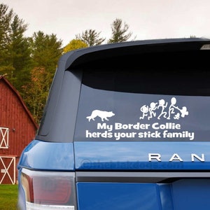 May include: A blue car with a white sticker on the back window. The sticker says "My Border Collie herds your stick family" and has a silhouette of a dog and a family.