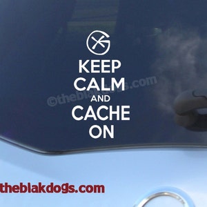 May include: A white vinyl sticker on a blue car with a compass symbol and the text "Keep Calm and Cache On".