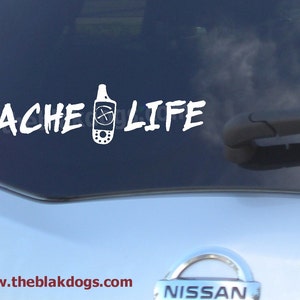 May include: White vinyl sticker on a car window that says "CACHE LIFE" with a stylized image of a GPS device.