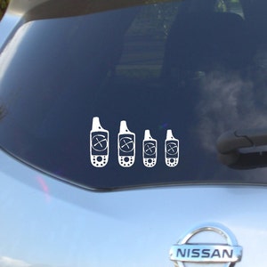 May include: A white car with a rear window sticker of four white GPS devices. The devices are in different sizes and have a crosshair symbol on the screen.