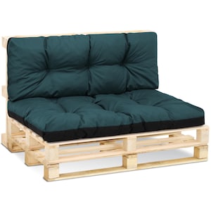 Op de afbeelding: Een teal-kleurige kussenset voor een palletbank. De kussens hebben een gestoffeerd ontwerp en liggen op een houten palletframe.