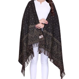 May include: A black and brown paisley patterned shawl with fringe. The shawl is made of wool and has a "TIBET" label.