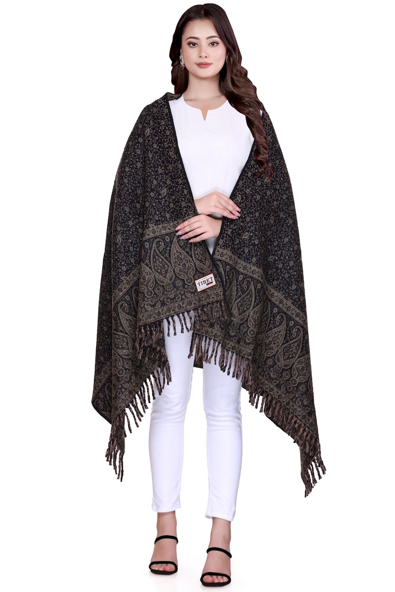 May include: A black and brown paisley patterned shawl with fringe. The shawl is made of wool and has a "TIBET" label.