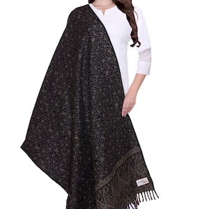 May include: A black shawl with a paisley pattern and fringe. The shawl is made of wool and has a label that says "TIBET".