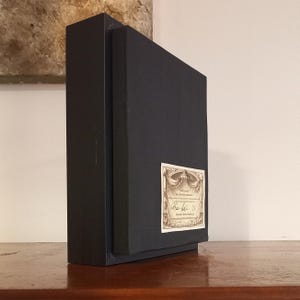 May include: A black box with a certificate of authenticity attached to the front. The certificate is printed on paper with a decorative border and includes the text "Limited Edition" and a signature.