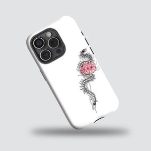 Puede incluir: Funda de teléfono blanca con una ilustración detallada de una serpiente entrelazada con una flor roja y blanca. La serpiente está representada en tonos grises y negros, creando un contraste con el fondo blanco.