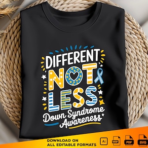 Könnte beinhalten: Schwarzes T-Shirt mit einer gelben und blauen Grafik, auf der "Anders, nicht weniger" mit einem Herzen und einem Band steht. Der Text "Down-Syndrom-Bewusstsein" befindet sich unter der Grafik.