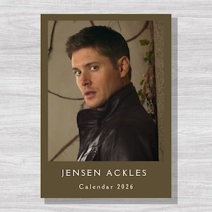 May include: A calendar featuring a portrait of Jensen Ackles. The image shows a man in a dark leather jacket, with the text "JENSEN ACKLES Calendar 2026" at the bottom. The background is a neutral color.