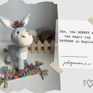 May include: A gray crocheted donkey toy standing on a colorful crocheted rug. The text "Dan, the DONKEY and the magic rug PATTERN in English" is written on a white background.
