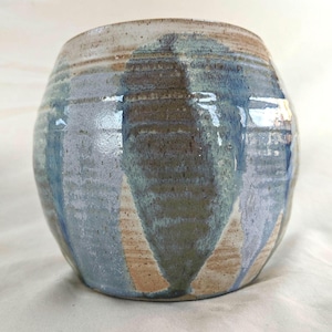 May include: A round ceramic planter with a light brown base and blue, green, and white glaze. The glaze has a streaky pattern.