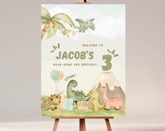 Op de afbeelding: Verjaardagsbord op een ezel, in aquarel-stijl. Het bord leest "Welkom op Jacob's Brul-achtige 3e Verjaardag" met dinosaurus illustraties, ballonnen en een vulkaan. Het kleurenpalet omvat groen, bruin en roze.