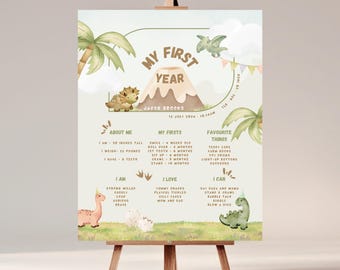 May include: A dinosaur-themed milestone poster for a baby's first year, displayed on a wooden easel. The poster includes illustrations of dinosaurs, palm trees, and a volcano. The poster includes the baby's name, date, and height.