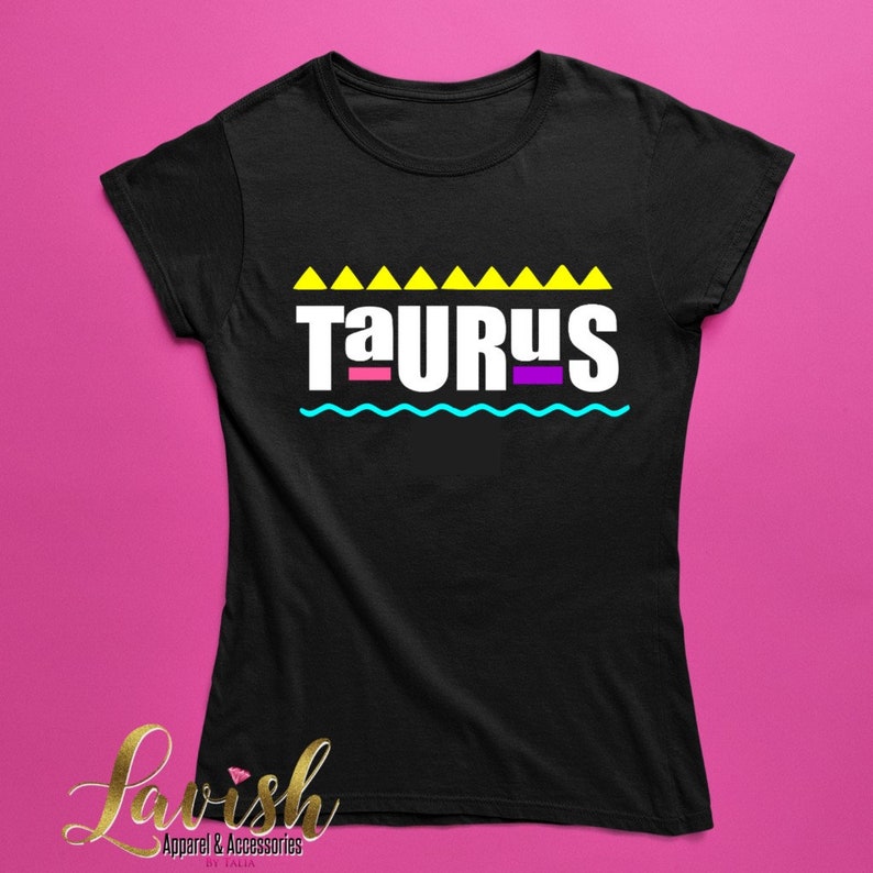 May include: Black t-shirt with a white graphic that says "Taurus" in a retro 90s style with yellow, pink, and blue accents.