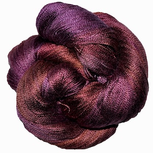 May include: A skein of deep purple and burgundy yarn with a subtle ombre effect. The yarn is soft and luxurious, perfect for knitting or crocheting.