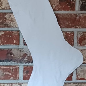 May include: A plain white Christmas stocking with a scalloped edge.