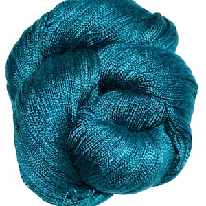 May include: A ball of teal-coloured yarn, tightly wound and textured. The yarn appears to be a luxurious fibre, with a slight sheen. The colour is a vibrant teal, with hints of blue and green. Suitable for knitting or crochet projects.