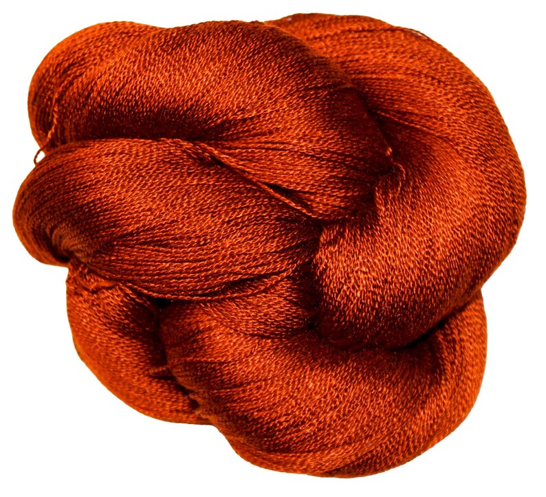 May include: A tightly wound skein of orange-red yarn, likely for knitting or crochet projects. The yarn has a fine, textured appearance, suggesting a soft and luxurious fiber. The color is a rich, warm tone, perfect for creating cozy items.