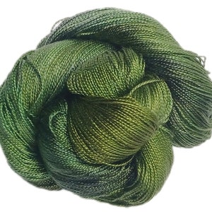 May include: A skein of green silk embroidery floss. The floss is tightly wound and has a subtle sheen.
