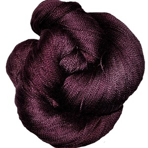 May include: A deep purple skein of yarn, made of a soft, textured fibre.
