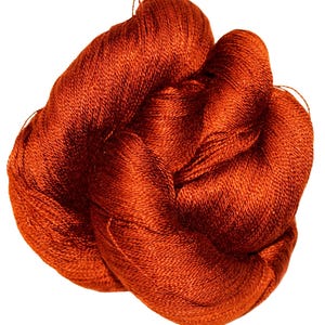 May include: A tangled skein of vibrant, rust-colored yarn. The yarn appears to be tightly spun, with a slight sheen, suggesting a smooth texture. The fibers are closely packed, forming a dense bundle. Ideal for knitting, crocheting, or other fiber arts projects.