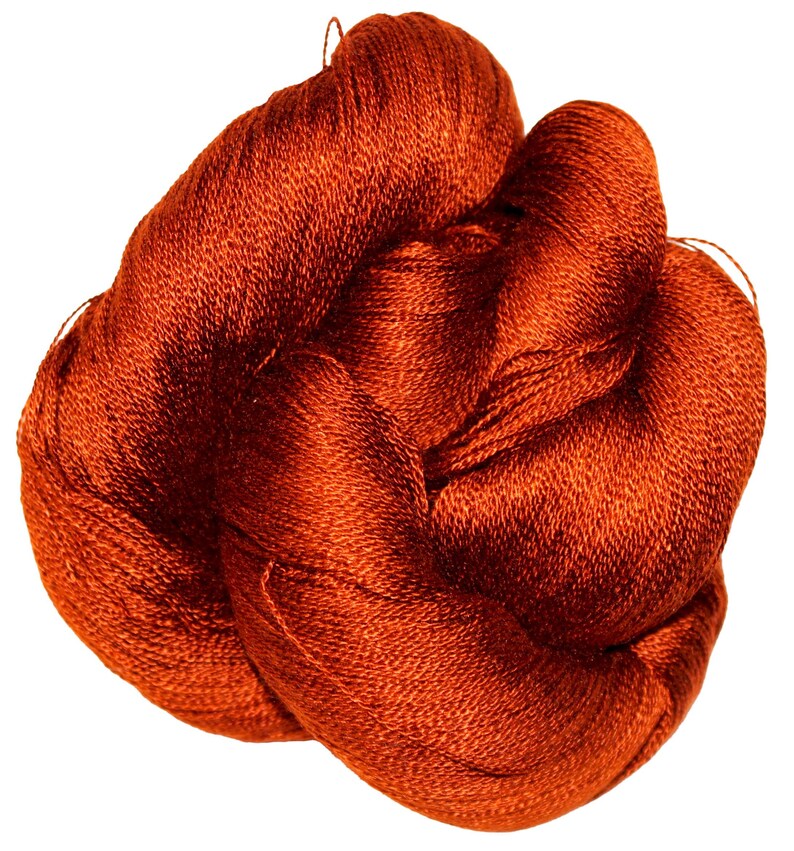 May include: A tangled skein of vibrant, rust-colored yarn. The yarn appears to be tightly spun, with a slight sheen, suggesting a smooth texture. The fibers are closely packed, forming a dense bundle. Ideal for knitting, crocheting, or other fiber arts projects.