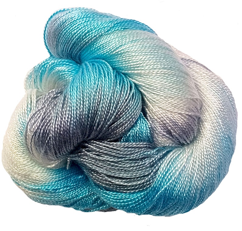 May include: A skein of blue, gray, and white ombre yarn. The yarn is soft and silky, and it is perfect for knitting or crocheting.
