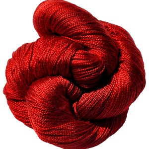 May include: A ball of deep red yarn, tightly coiled and showing a textured surface. The yarn has a subtle sheen, suggesting a high-quality fibre. The close-up shot emphasizes the detailed construction, suitable for knitting or crochet.